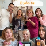 Das Team der Bona-Lingua-Praxis in der Lister Meile feiert zehn Jahre List: sieben Kolleginnen und Kollegen pusten bunte Federn von der Hand, eine weitere ist per Video auf einem Tablet dabei.
